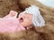 0-1 month Asian newborn baby lie down on brown fur in studio, toddler infant open eye seeking some voice near her, baby hungry