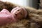 0-1 month Asian newborn baby lie down on brown fur in studio, toddler infant open eye seeking some voice near her, baby open eye