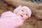 0-1 month Asian newborn baby lie down on brown fur in studio, toddler infant open eye seeking some voice near her, baby open eye