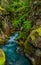 0000262_Bright blue waters of Avalanche Creek amid colorful foliage_4809