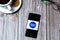 03-10-2021 Portsmouth, Hampshire, UK A Mobile phone or cell phone laid on a wooden table with the Citizens advice bureau logo on