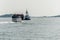 04.09.2017 Boston Massachusetts USA commuter ferry coming across Boston Harbor passing big freight ship with tugboat