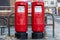 08/02/2020 Portsmouth, Hampshire, UK two red Royal mail post boxes side by side on a street with a sticker stating priority post