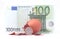 1 Euro coin getting out of cracked hatched egg near 100 euro banknote
