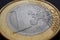 1 one euro coin close-up. The name of the Eurozone currency in focus. Background for news about economy and finance of the