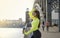 1 sports girl with long hair in a green sports top stands on the bridge at sunset, a girl with a bottle of water in her hands on