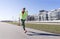 1 white chubby woman running in the city on the street in the background of buildings, runner