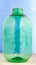 A 10 liter glass jar is made of thick green glass on a blue background