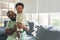 A 10-month-old Nigerian baby boy standing on his father\'lap, smiling and happy