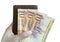 10 Riyal Saudi money banknotes in hand on the top of wallet on white background.