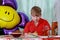 A 10-year-old boy eating a sweet berry pie.On a blue - blue background, close-up. Boy, young, child, desserts, candy, cookies, hap