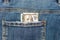 A 100 dollar bill peeps out of his jeans pocket. Close-up, horizontal photo. Concept - a stash for a rainy day, pocket money