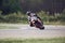 11-05-2020 Riga, Latvia. Motor biker on a race circuit speeding round a corner with a race circuit kerb behind