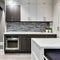 11 A laundry room with a mix of white and gray finishes, a large, graphic tile backsplash, and a mix of open and closed storage2