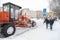 13.02.2021, Russia, Moscow. Clearing the road from the snow cover after the snowfall by tractor with a bucket