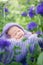 17 day old Smiling newborn baby is sleeping on his stomach in the basket on nature in the garden outdoor