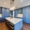 18 A laundry room with a mix of white and blue finishes, a large, built-in folding counter, and a mix of open and closed storage