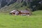 19.08.2021 Seealpsse Switzerland: old style alpine dairy built next to a rock wall, empty milk cans in front of the house, german