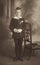 1910-1920 first or holy communion studio photo, a young boy in suit holding the bible for his portrait