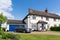 1920`s Former council house with car in the drive. Hertfordshire. UK