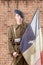 1940 french soldier with a flag, wall of red brick at the back