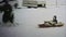 1973: Dog wildly pulling child on winter snow sled.