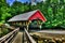 19th Century covered bridge with a wooden walk along side of it HDR.