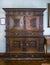 A 19th-century wooden carved cabinet made in Bavaria in the Old German Style, with a plaque on the wall describing its history