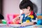 2-3 years old Asian boy is coloring with chalk color on paper placed. Cute baby do handicrafts, make development of hand muscles.