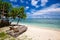 2 bamboo sun loungers on a white sand beach relaxing by a tropical sea