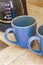 2 blue coffee cups and black coffee maker from Mexico