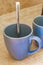 2 blue coffee cups and black coffee maker from Mexico