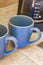 2 blue coffee cups and black coffee maker from Mexico