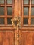 2 brass statues and a wreath of dried flowers on an old wooden door