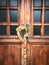 2 brass statues and a wreath of dried flowers on an old wooden door