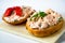 2 canapÃ©s with salmon spread with fresh cheese on kitchen board