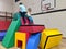 2 children climbing to the top of a soft play fort