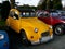 2 cv old yellow French cars on parking lot.