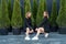 2 girls in black tracksuits posing near thuja.