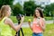 2 girls are a student. Summer in nature. Record video on the camera, for its subscribers. Concept of young bloggers