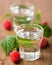 2 glasses of raspberry schnapps with raspberries on wooden board