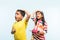 2 indian kids flying kite, one holding spindal or chakri