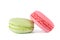 2 macaron cookies green and pink, on white background