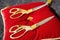 2 pairs of ribbon cutting scissors lying on a red velvet pillow close up