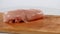 2 pieces of raw chicken fillet falls on a wooden board, than taken from a wooden plank by hand