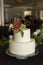 2 tier wedding cake decorated with pleated buttercream and edible rose floral arrangement