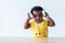 A 2-year-old Nigerian girl with beautiful curly hair, trying on her headphones herself