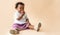 A 2-year-old Nigerian girl sitting on the floor and eating fresh red apples happily