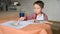 A 2 years old child draws a rainbow with paints. Creative activities at home concept. Children\\\'s desk, drawing supplies