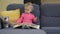 2 years old lovely baby girl sit on sofa read story book and show emotions.